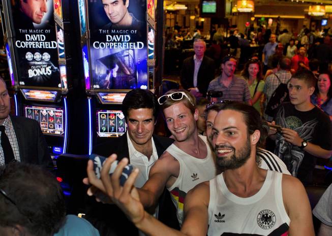 David Copperfield poses for pictures with fans during the unveiling his new slot machine at the MGM Grand on Thursday, June 26, 2014.