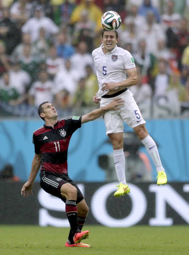 United States' Matt Besler goes up to head the ball over Germany's Miroslav Klose during the group G World Cup soccer match between the United States and Germany at the Arena Pernambuco in Recife, Brazil, Thursday, June 26, 2014. 