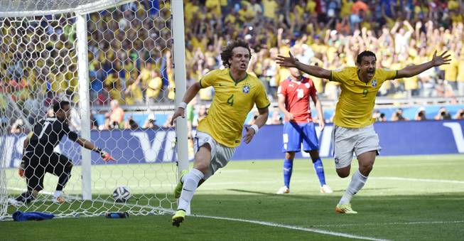 Brazil's David Luiz, left, and Fred celebrate after Brazil's opening goal during the World Cup round of 16 soccer match against Chile at the Mineirao Stadium in Belo Horizonte, Brazil, on Saturday, June 28, 2014.