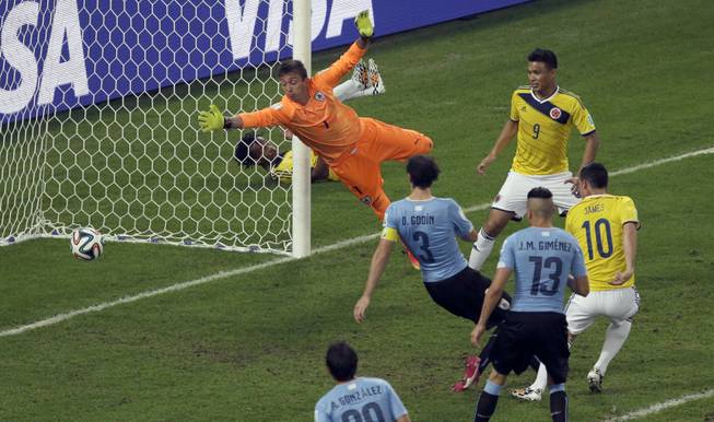 Colombia's James Rodriguez, right, scores his side's second goal past Uruguay goalkeeper Fernando Muslera during a World Cup round of 16 soccer match at the Maracana Stadium in Rio de Janeiro, Brazil, on Saturday, June 28, 2014.