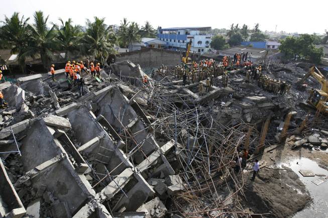 Rescuers search for workers believed buried in the rubble of a building that collapsed on the outskirts of Chennai, India, Sunday, June 29, 2014. The 12-story apartment structure the workers were building collapsed late Saturday while heavy rains and lightning were pounding. Police said 31 construction workers had been pulled out so far and the search was continuing for more than a dozen others.