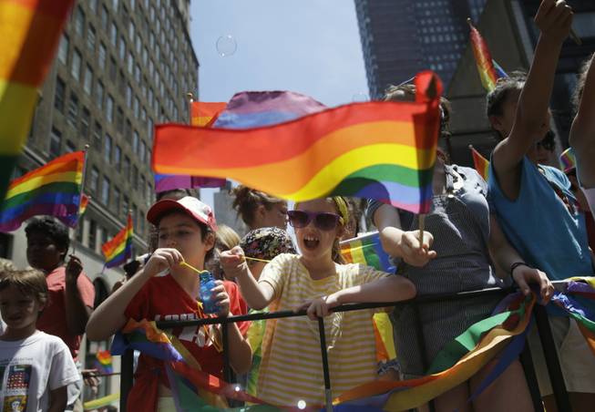 Children blow bubbles as they pass by on a float in the Gay Pride Parade in New York on Sunday, June 29, 2014. Fifth Avenue became one big rainbow on Sunday, as thousands of participants waving multicolored flags made their way down the street for New York City's annual Gay Pride march.