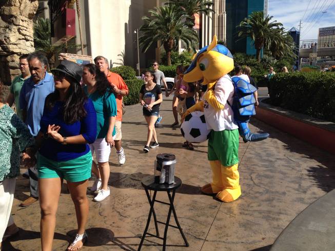 Street performer Cheikh "Louis" Diakhate, dressed as the World Cup mascot Fuleco, is ignored by pedestrians on the Las Vegas Strip on Thursday, June 26, 2014.