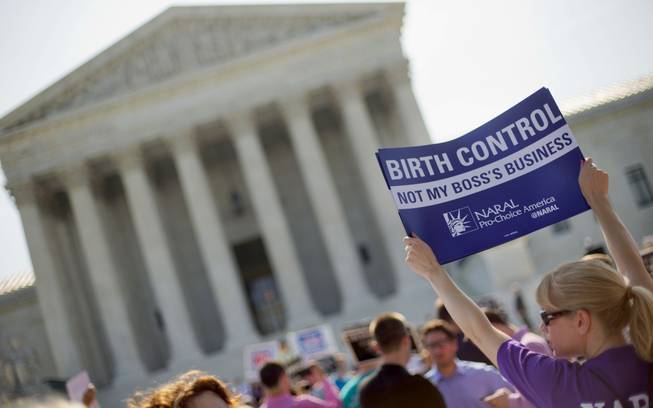 A demonstrator holds up a sign outside the Supreme Court in Washington, Monday, June 30, 2014. The Supreme Court is poised to deliver its verdict in a case that weighs the religious rights of employers and the right of women to the birth control of their choice.