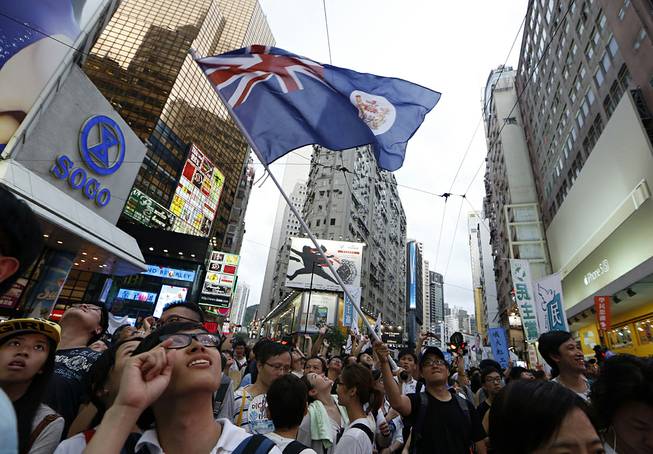 A protester waves a Hong Kong colonial flag as people march during an annual protest in downtown Hong Kong Tuesday, July 1, 2014. 