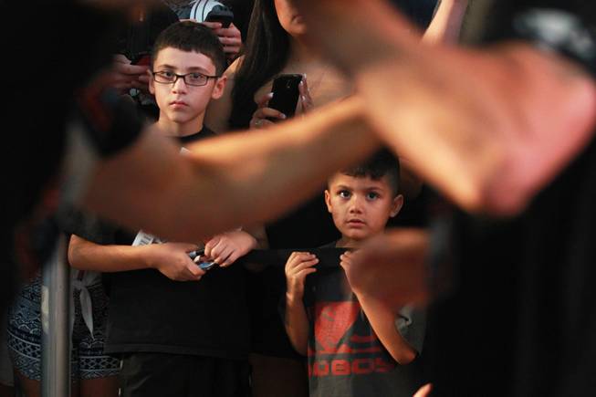 Young fans watch as Chris Weidman loosens up during the open workout for UFC 175 Wednesday, July 2, 2014 at the Fashion Show Mall.