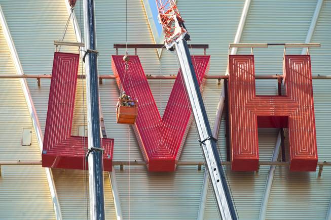 David Siegel, Founder and CEO of Westgate Resorts, is hoisted up over 200 feet to remove the LVH letters off the main sign of Westgate's newly purchased property, Tuesday July 1, 2014.