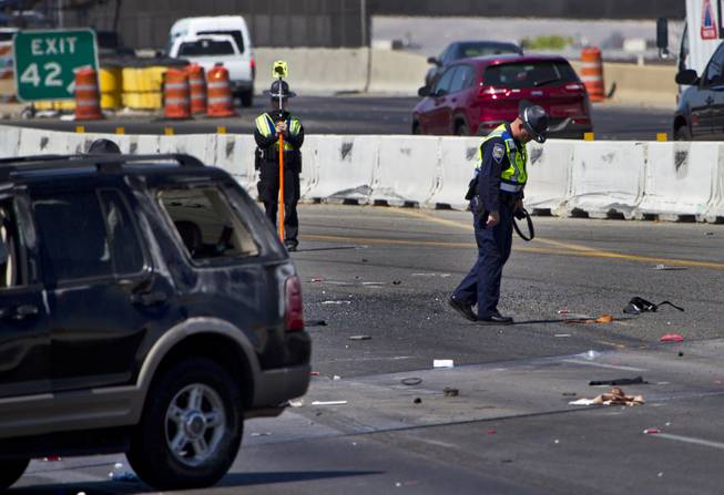 Las Vegas Metro Police continue to document the scene of a fatal car crash on the I-15 just north of the I-95 interchange on Wednesday, July 2, 2014.