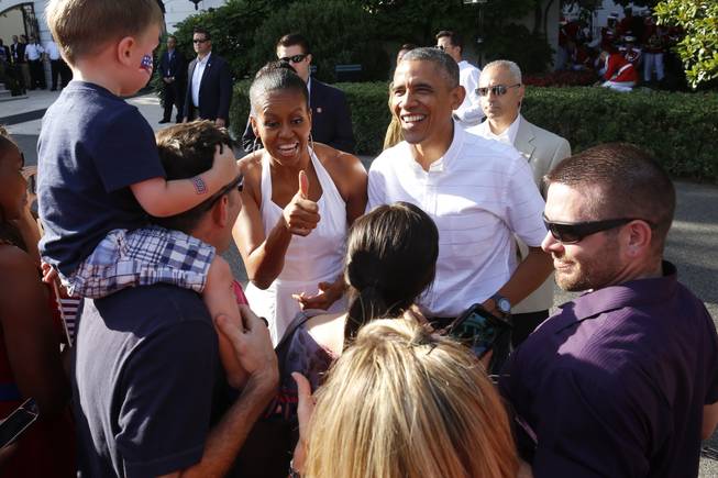 President Barack Obama and first lady Michelle Obama greet military families as they host an Independence Day celebration on the South Lawn at the White House in Washington, Friday, July 4, 2014.