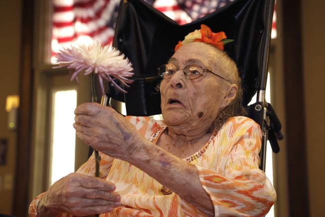 Gertrude Weaver holds a flower given to her a day before her 116th birthday at Silver Oaks Health and Rehabilitation Center in Camden, Ark., on Thursday, July 3, 2014. The Gerontology Research Group says Weaver is the oldest person in the United States and second oldest in the world.