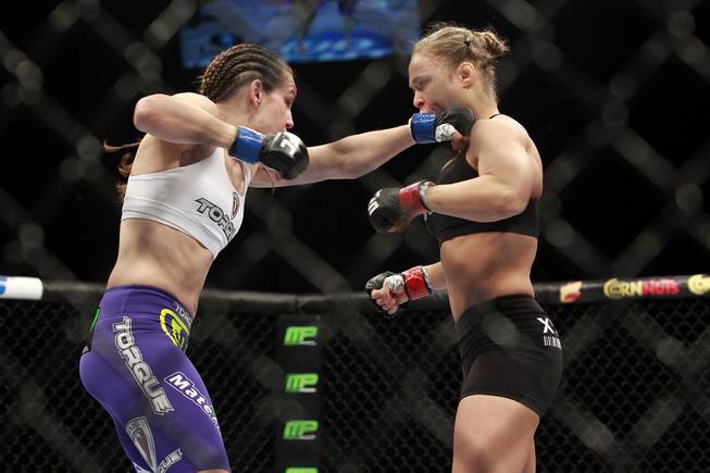 Ronda Rousey gets hit with a left by Alexis Davis during their fight at UFC 175 at the Mandalay Bay Events Center Saturday, July 5, 2014. Rousey retained her title with a 16-second TKO.