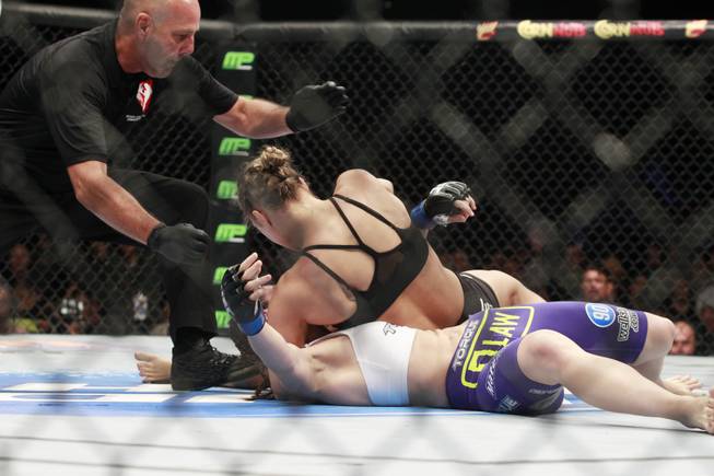 Referee Yves Lavigne steps in to stop Ronda Rousey as she pounds Alexis Davis during their fight at UFC 175 at the Mandalay Bay Events Center Saturday, July 5, 2014.