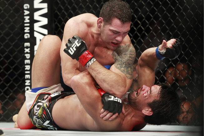 Chris Weidman throws elbows at Lyoto Machida during their fight at UFC 175 at the Mandalay Bay Events Center Saturday, July 5, 2014. Weidman won a unanimous decision to retain his middleweight belt.