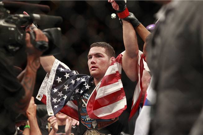 Chris Weidman raises his arms after defending his middleweight title against Lyoto Machida with a unanimous decision at UFC 175 at the Mandalay Bay Events Center Saturday, July 5, 2014.