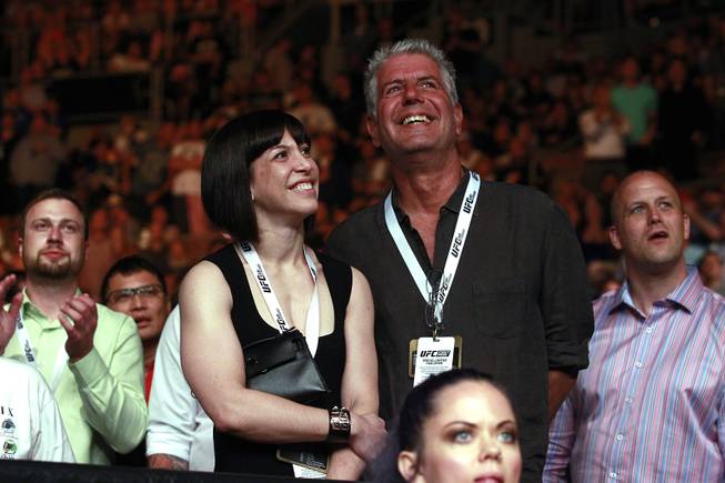 Chef, author and TV personality Anthony Bourdain and his wife Ottavia Busia smile between rounds of Chris Weidman's fight against Lyoto Machida during UFC 175 at the Mandalay Bay Events Center Saturday, July 5, 2014. Weidman won a unanimous decision to retain his middleweight belt.