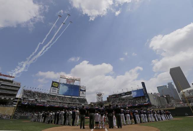 Military aircraft fly over Target Field during the national anthem as part of Military Appreciation Day before a baseball game between the New York Yankees and the Minnesota Twins in Minneapolis, Sunday, July 6, 2014.