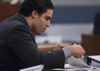 Joey Kadmiri looks through paperwork's his trial begins, he was  allegedly beat up by the Thunder From Down Under Male Revue dancers after trying to burglarize their locker room Tuesday, July 8, 2014.