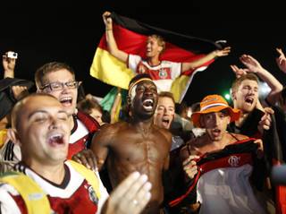 Germany soccer fans celebrate their team's 7-1 victory over Brazil after watching the World Cup semifinal match on a live telecast inside the FIFA Fan Fest area on Copacabana beach in Rio de Janeiro, Brazil, Tuesday, July 8, 2014. (AP Photo/Leo Correa)