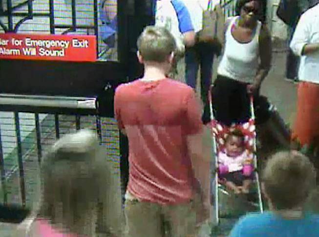 In this Monday, July 7, 2014 surveillance camera image provided by the New York Police Department, a woman, top right, pushes her baby girl in a stroller at the Columbus Circle subway station in New York. The 20-year-old woman, who is suspected of abandoning the baby at the Manhattan station, was in police custody on Tuesday. 