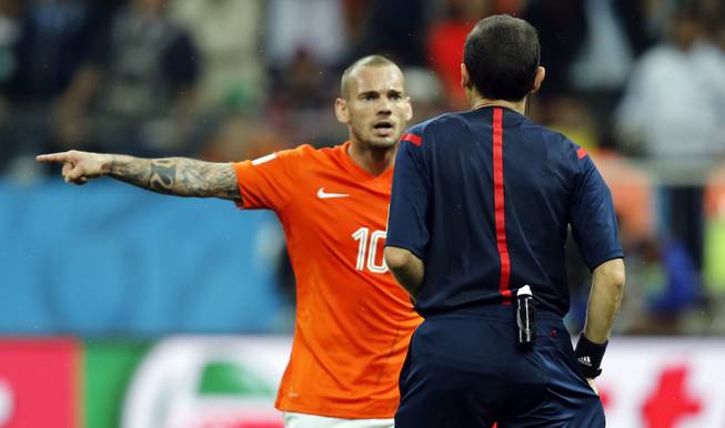 Netherlands' Wesley Sneijder argues with referee Cuneyt Cakir from Turkey during the World Cup semifinal soccer match between the Netherlands and Argentina at the Itaquerao Stadium in Sao Paulo, Brazil, Wednesday, July 9, 2014. 
