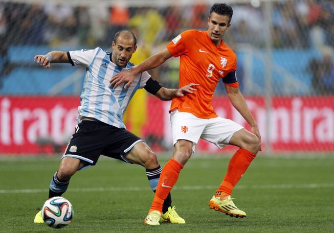 Argentina's Pablo Zabaleta, left, and Netherlands' Robin van Persie challenge for the ball during the World Cup semifinal soccer match between the Netherlands and Argentina at the Itaquerao Stadium in Sao Paulo, Brazil, Wednesday, July 9, 2014. 