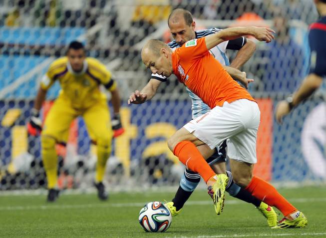 Netherlands' Arjen Robben, front, and Argentina's Pablo Zabaleta challenge for the ball during the World Cup semifinal soccer match between the Netherlands and Argentina at the Itaquerao Stadium in Sao Paulo, Brazil, Wednesday, July 9, 2014. 