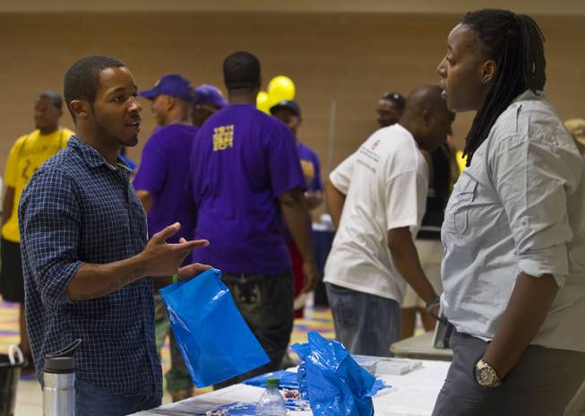 Attendees talk during a Stop the Violence event at the Pearson Community Center featuring local support agencies on Saturday, June 28, 2014.