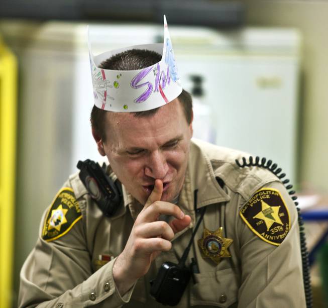 Metro Police Officer Gordie Bush, in paper and crayon hat, sings a song with others at the Sherman Gardens Youth Center on Thursday, July 3, 2014.