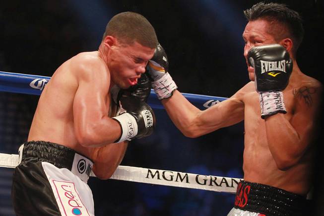 Juan Manuel Lopez, left, takes a punch from Francisco Vargas during their lightweight title fight Saturday, July 12, 2014 at the MGM Grand Garden Arena.