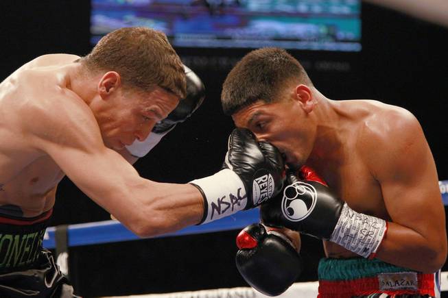 Abner Mares takes a punch from Jonathan Oquendo during their featherweight fight Saturday, July 12, 2014 at the MGM Grand Garden Arena.