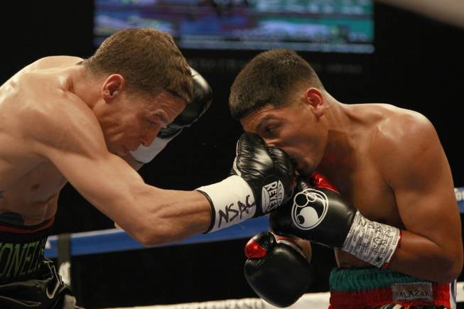 Abner Mares takes a punch from Jonathan Oquendo during their featherweight fight Saturday, July 12, 2014 at the MGM Grand Garden Arena. 
