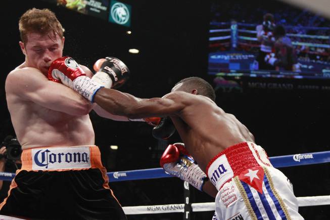 Saul "Canelo" Alvarez, left, takes a punch from Erislandy Lara during their super welterweight fight Saturday, July 12, 2014 at the MGM Grand Garden Arena.