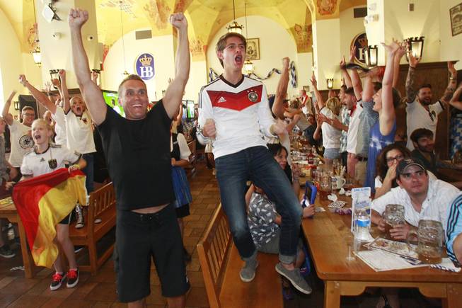 Germany fans react to their team scoring a goal in extra time while watching the World Cup final game against Argentina at the Hofbrauhaus Sunday, July 13, 2014.