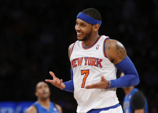 In this Feb. 24, 2014, file photo, New York Knicks' Carmelo Anthony smiles after hitting a 3-point shot against the Dallas Mavericks during an NBA basketball game in New York. Anthony is remaining with the Knicks, saying he wants "to stay and build here with this city and my team." Anthony made his decision official Sunday with a posting on his website. He writes: "In the end, I am a New York Knick at heart."