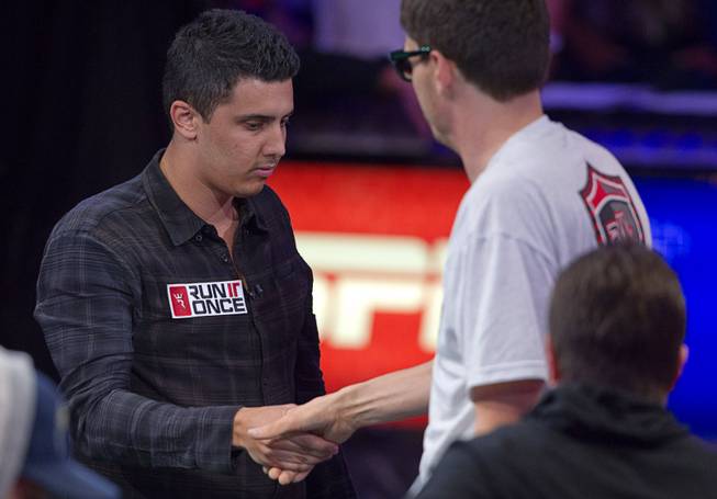Craig McCorkell of Britain shakes hands with Mark Newhouse after being knocked out of the World Series of Poker $10,000 buy-in No-limit Texas Hold 'em main event at the Rio Monday, July 14, 2014. McCorkell finished in 13th place.