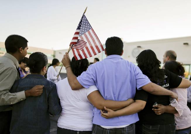 Martin Martinez, center, and his wife, Blanca Martinez, third from left, gather for a photo outside the Immigration and Customs Enforcement offices during an immigration vigil, Wednesday, April 10, 2013, in Las Vegas. During the process in which Blanca Martinez, a U.S. citizen, applied for a petition for her husband to obtain a Green Card, Martin was detained by ICE officials for nearly two weeks and nearly deported back to El Salvador before being released. The vigil was held to honor all who have been detained or deported by ICE.