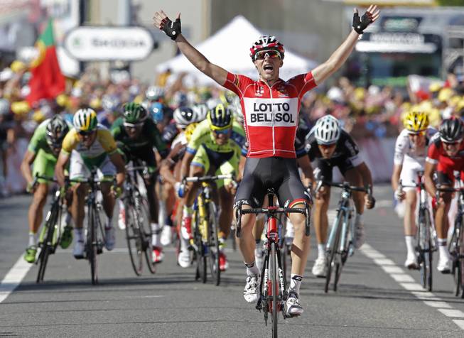 France's Tony Gallopin manages to stay ahead of the spring pack, rear, as he crosses the finish line to win the eleventh stage of the Tour de France cycling race over 187.5 kilometers (116.5 miles) with start in Besancon and finish in Oyonnax, France, Wednesday, July 16, 2014.