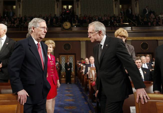 Senate Minority Leader Mitch McConnell, left, and Senate Majority Leader Harry Reid head to the front of the chamber before President Barack Obama delivers his State of the Union speech on Capitol Hill in Washington on Tuesday, Jan. 28, 2014.