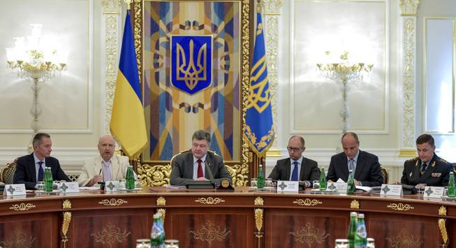 Ukrainian President Petro Poroshenko, third left, chairs a Security Council meeting in Kiev, Ukraine, Thursday, July 17, 2014. Ukrainian President Petro Poroshenko called the downing of a Malaysia Airlines passenger plane an act of terrorism and called for an international investigation into the crash. Poroshenko insisted that his forces did not shoot down the plane. From right, Ukrainian Defense MInister Valery Heletey, Head of the Security Council Andriy Parubiy, Prime Minister Arseniy Yatsenyuk, Petro Poroshenko, parliament speaker Oleksandr Turchynov. 