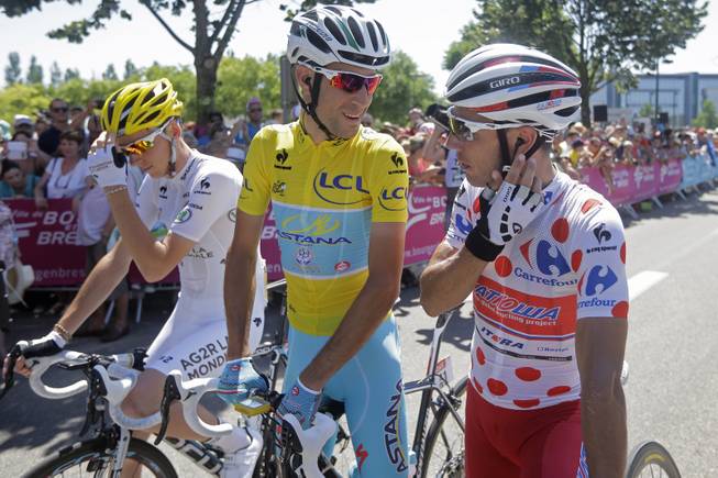 Italy's Vincenzo Nibali, wearing the overall leader's yellow jersey, talks to Spain's Joaquim Rodriguez, wearing the best climber's dotted jersey, as they wait with France's Romain Bardet, wearing the best young rider's white jersey, for the start of the twelfth stage of the Tour de France cycling race over 185.5 kilometers (115.3 miles) with start in Bourg-en-Bresse and finish in Saint-Etienne, France, Thursday, July 17, 2014. 