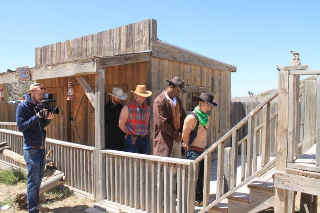 Videographer Mike Thompson shoots a lineup of cast members as convicts, from left, Jake Alberda, Lucasz Sczerba, Ming Hukari and Kyle Vonn Elzey 
during the video shoot for Melody Sweets' "Shoot 'em Up" at Grand Canyon Ranch on April 22, 2014.