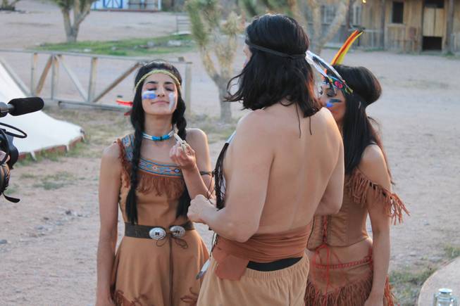 Penny Pibbets, joined by crossbow artists Ottavio and Naomi Gesmundo, enjoys what appears to be a peace pipe during the video shoot for Melody Sweets' "Shoot 'em Up" at Grand Canyon Ranch on April 22, 2014.