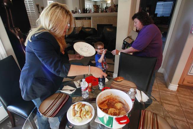 Michelle Fiore serves up ravioli while her mother Lill Fiore hands Jake Willis a toy May 8, 2014.