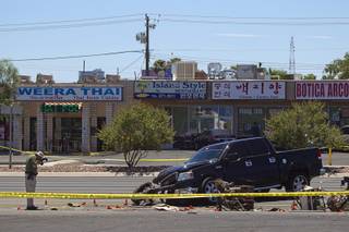 A Metro crime scene analyst takes a photo at a fatal accident on Sahara Avenue near Valley View Boulevard Sunday, July 20, 2014. A man who was apparently working on the sidewalk was killed in the accident.