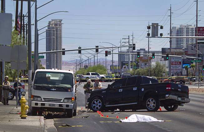 A Metro Police team investigate a fatal accident on Sahara Avenue near Valley View Boulevard Sunday, July 20, 2014. A man who was apparently working on the sidewalk was killed in the accident. 
