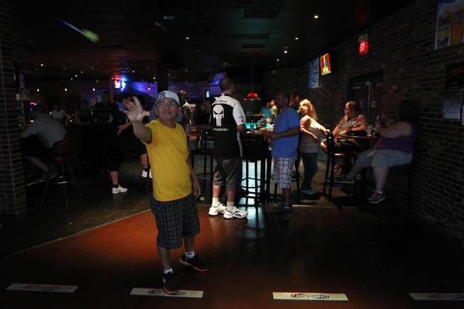 Ricky Canque throws during a meeting of the Las Vegas Darts league Wednesday, July 2, 2014 at the Crowbar.