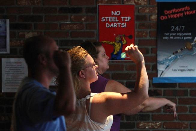 Members warm up during a meeting of the Las Vegas Darts league Wednesday, July 2, 2014 at the Crowbar.