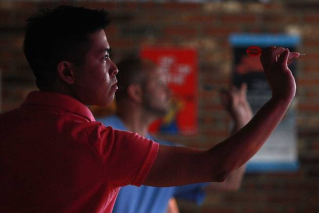 Kenneth Santiago throws during a meeting of the Las Vegas Darts league Wednesday, July 2, 2014 at the Crowbar.