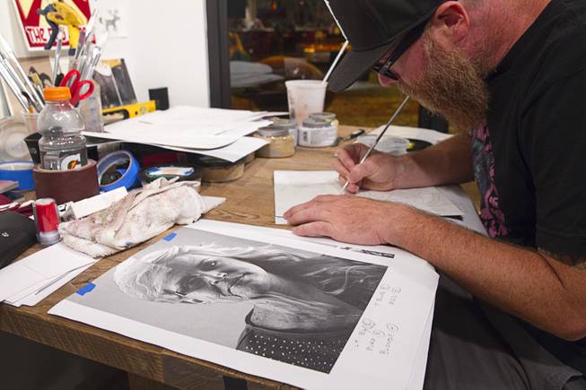 Artist JW Caldwell works on artwork based on a composite portrait in the P3 Studio in the Cosmopolitan Monday, July 21, 2014. For their project, photographer Todd Duane Miller combines portraits of people and Caldwell creates artwork from the composite photos.