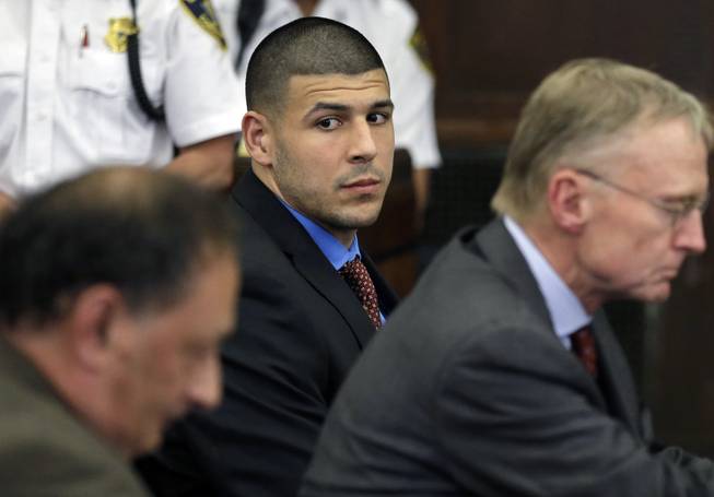 In this Tuesday, June 24, 2014, photo, former New England Patriots player Aaron Hernandez looks toward defense attorneys James Sultan and Charlie Rankin during a hearing in Suffolk Superior Court in Boston. Hernandez is charged in the 2012 shooting deaths of Daniel de Abreu and Safiro Furtado after an encounter at a Boston nightclub.